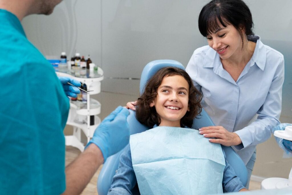 Teen smiling during orthodontic consultation with parent